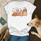 White t-shirt with four dogs in pumpkins and falling autumn leaves graphic.