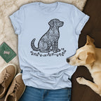 Light blue t-shirt with black dog silhouette made of hearts, flat lay.