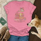 Pink t-shirt with dog, flowers, and text: "Grow Through It With A Dog Beside You".