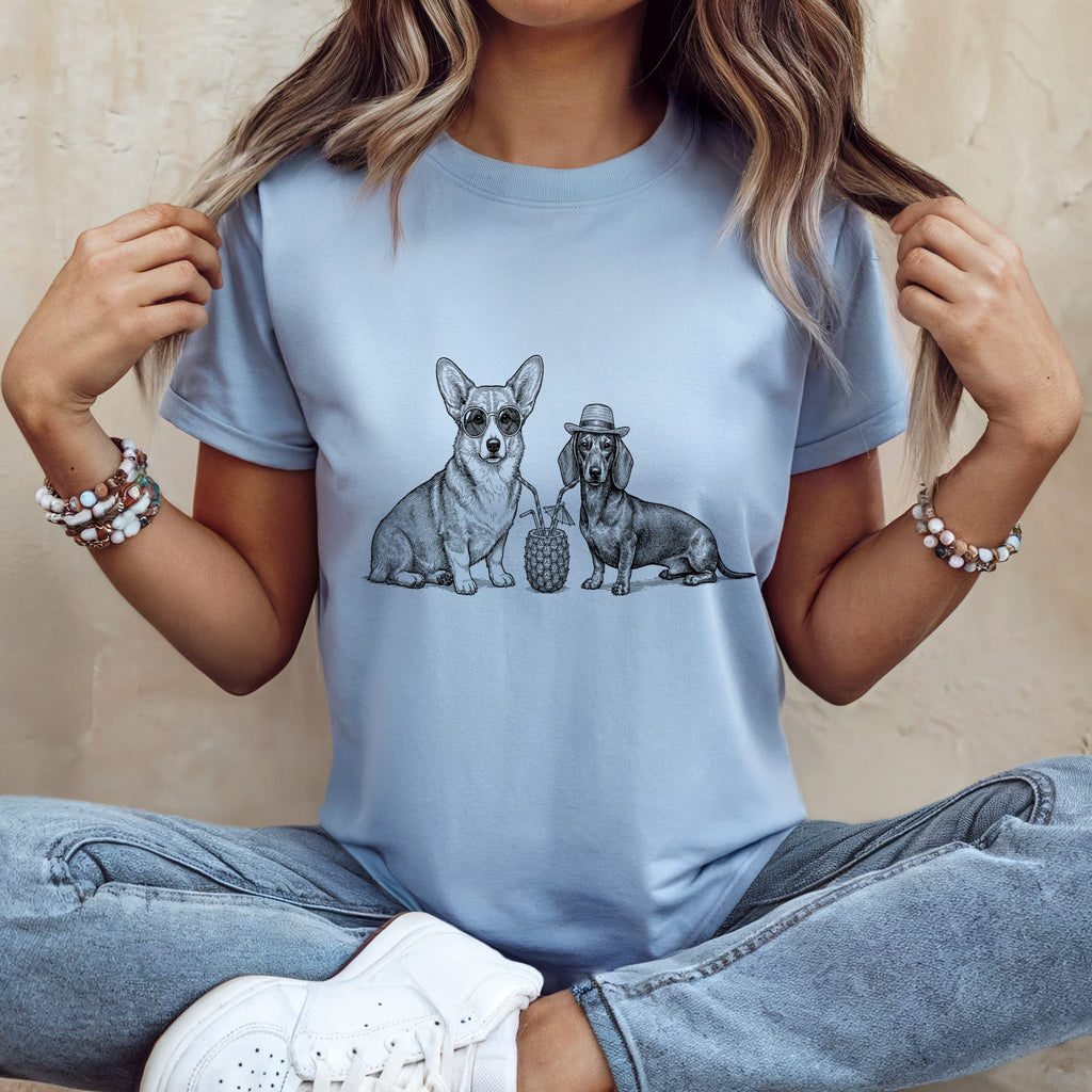 Corgi and dachshund wearing hats, sitting next to a pineapple on a t-shirt.