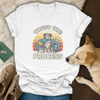 White t-shirt with graphic of two dogs and text "TRUST THE PROCESS".