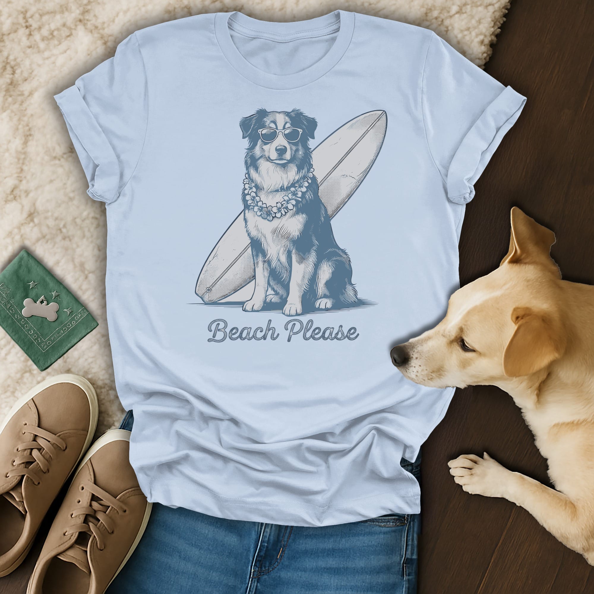 Blue t-shirt with a dog in sunglasses and a lei leaning on a surfboard, text "Beach Please".