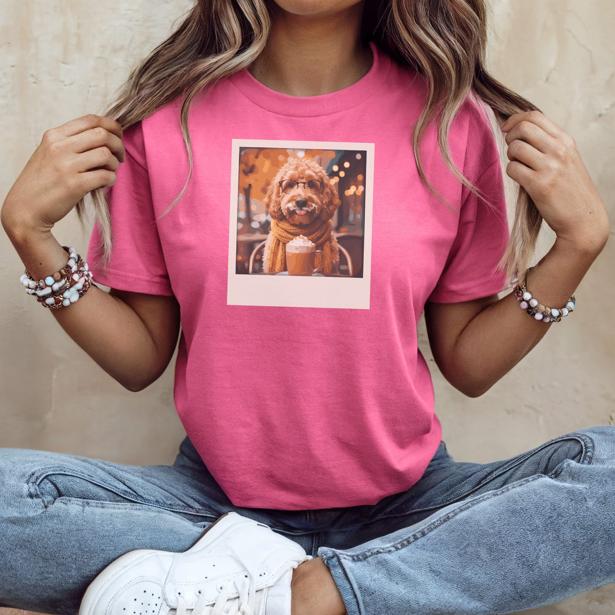Pink t-shirt with a dog wearing glasses and a scarf, holding a coffee.