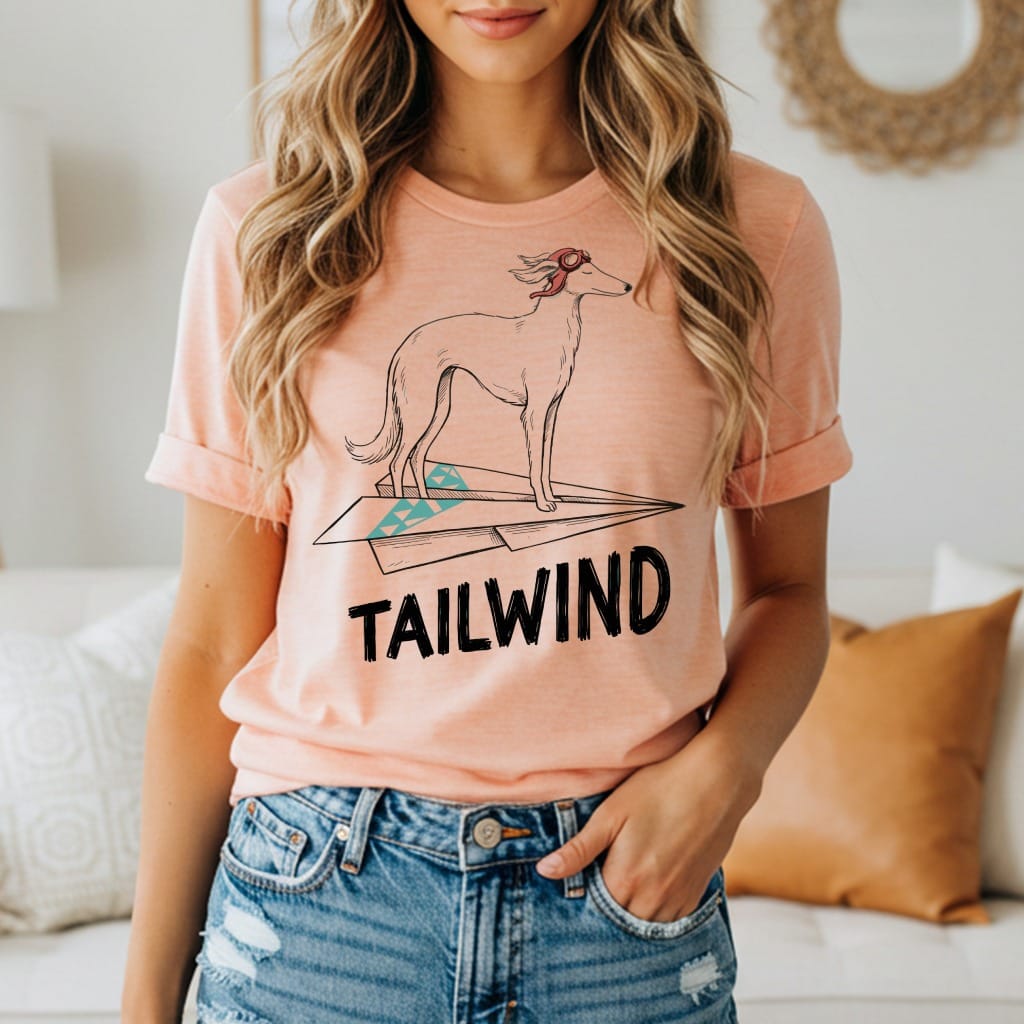 Peach t-shirt with a greyhound on a paper airplane and "TAILWIND" text.