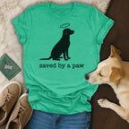 Green t-shirt with black dog silhouette and paw print halo, "saved by a paw" text.