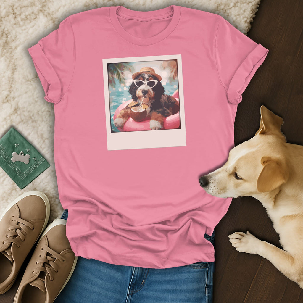 Pink t-shirt with a polaroid-style print of a dog wearing sunglasses and a hat, floating on a pool float.
