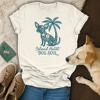 Cream t-shirt with teal graphic of a dog, palm tree, and text "Island Heart DOG SOUL."