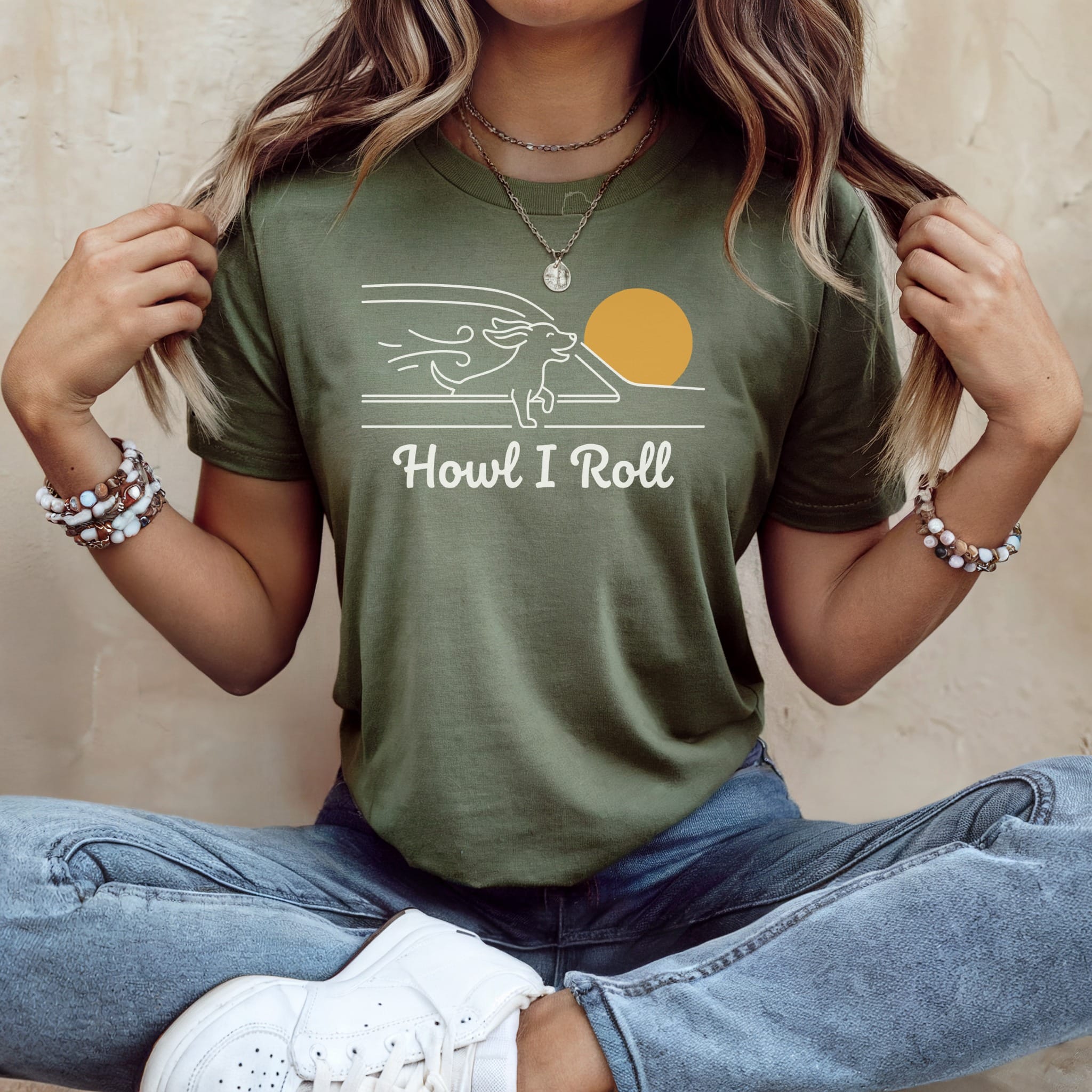 Olive green t-shirt with "Howl I Roll" text and minimalist sun and dog design.