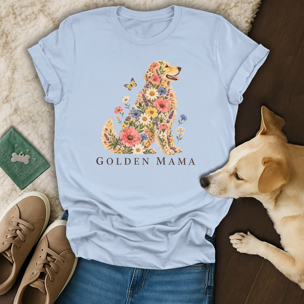 Light blue t-shirt featuring a floral golden retriever graphic and the text GOLDEN MAMA, surrounded by casual accessories and a real dog.