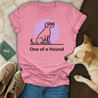 Pink t-shirt with a dog silhouette wearing pink sunglasses and text "One of a Hound".
