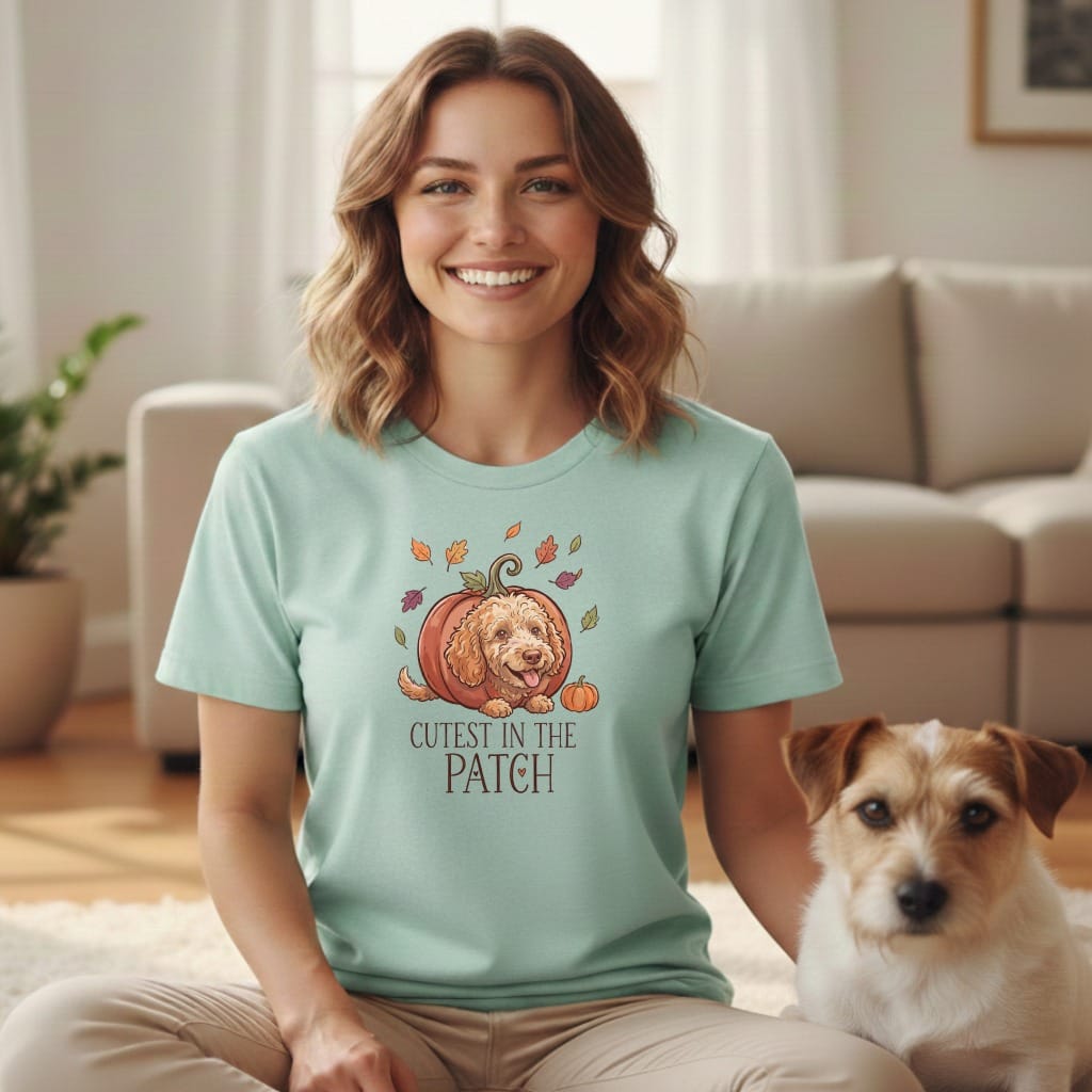Mint t-shirt with a dog peeking out of a pumpkin, reads "Cutest in the Patch".