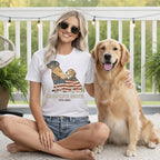 Woman wearing white t-shirt with American flag and dog graphic, Golden Retriever on lap.