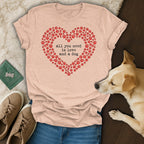 Heart-shaped paw print graphic with text "all you need is love and a dog" on a t-shirt.