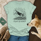 Light green t-shirt with a beagle dog illustration jumping in leaves, text "LEAF ME ALONE".