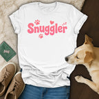 White t-shirt with pink "Snuggler" text, paw prints, and hearts.
