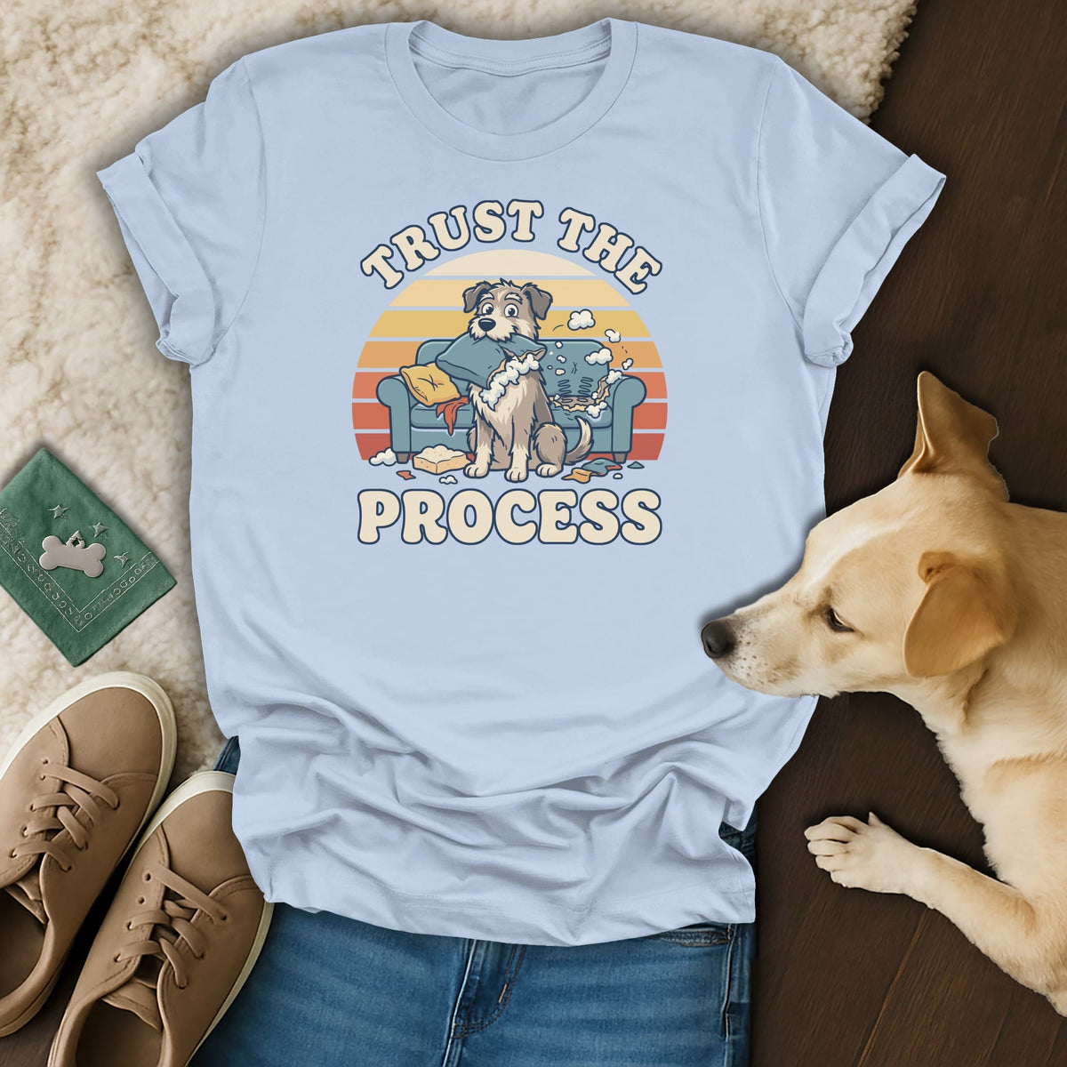 Light blue t-shirt with cartoon dog on a messy couch, text "TRUST THE PROCESS".