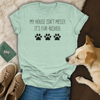 Light green t-shirt with text "MY HOUSE ISN'T MESSY. IT'S FUR-NISHED." and paw prints.