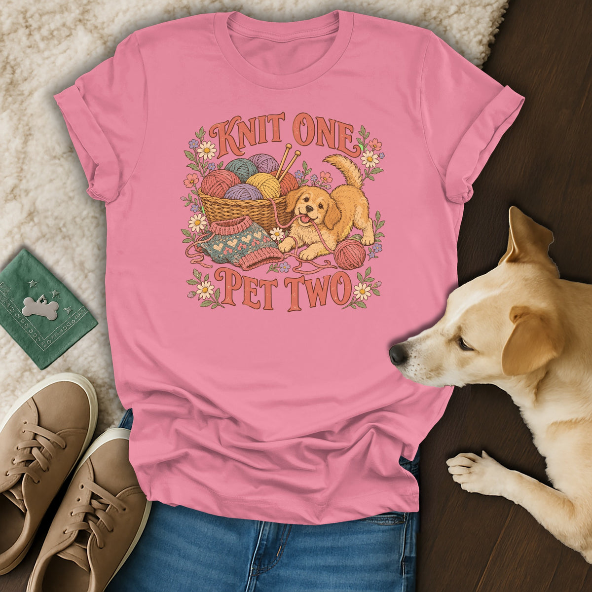 Pink t-shirt with a graphic of a puppy, yarn, and the text Knit One Pet Two.