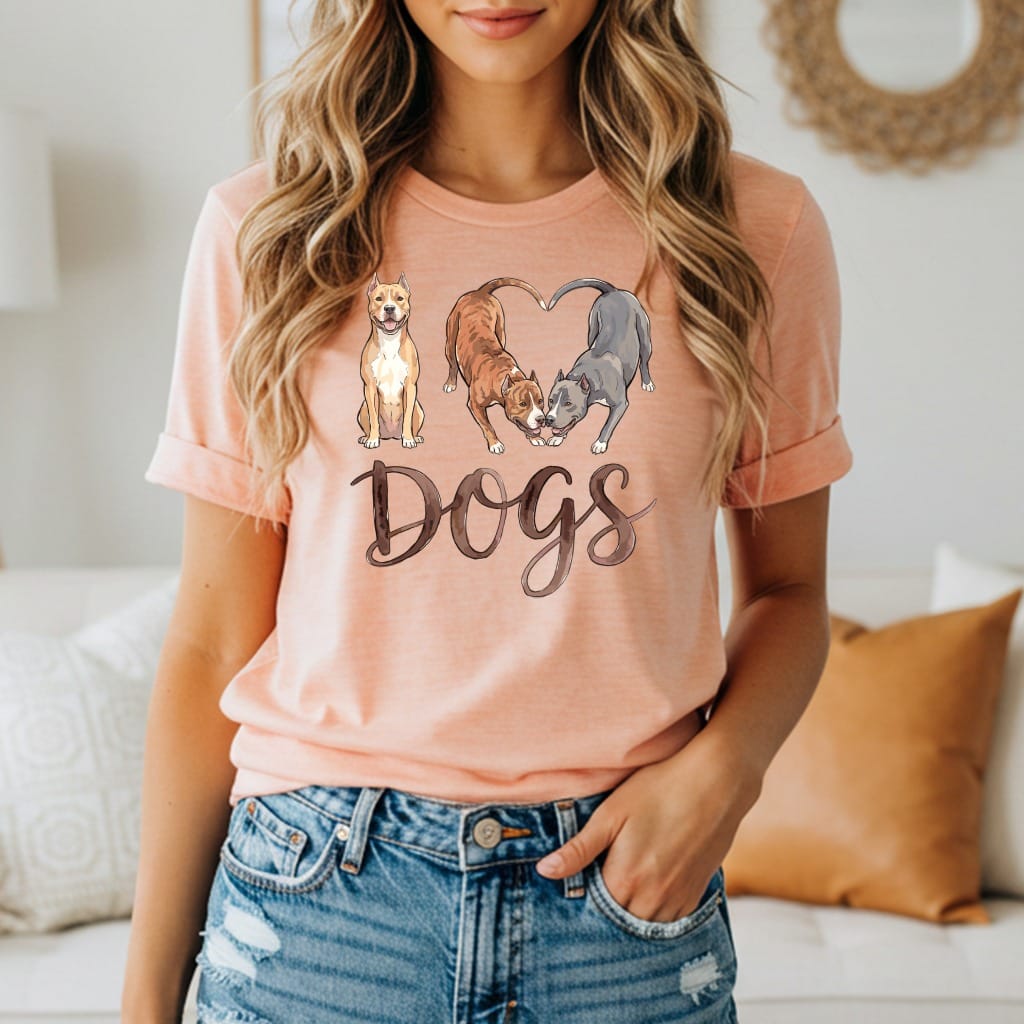 Three dogs in a heart shape above the word "Dogs" on a peach t-shirt.
