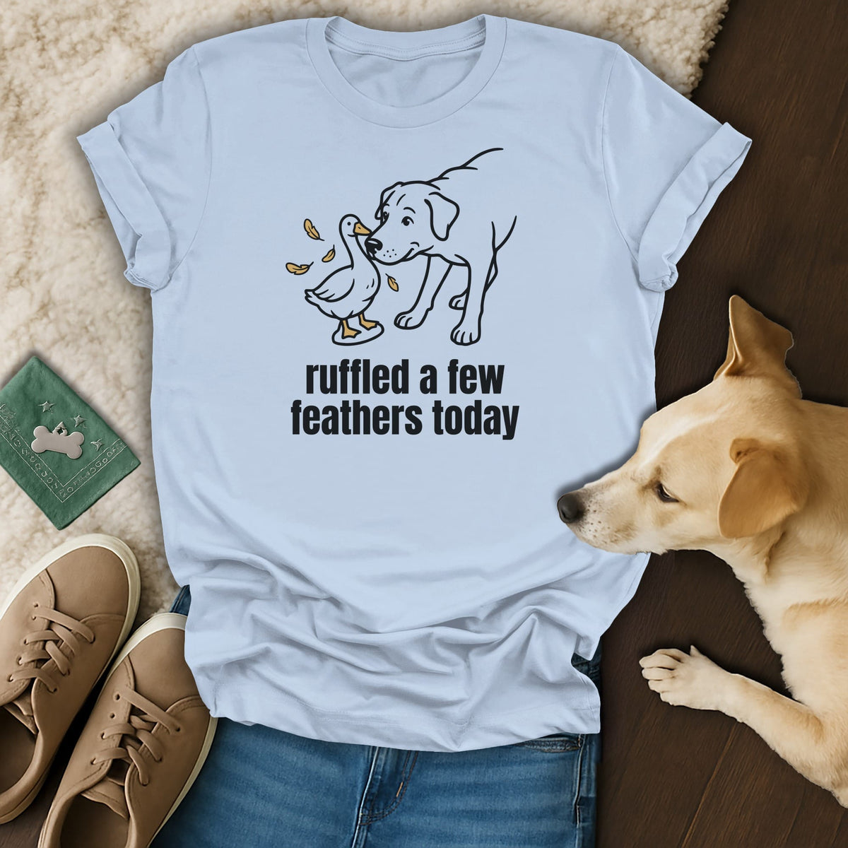 Light blue t-shirt with line drawing of a dog and duck, and text "ruffled a few feathers today".