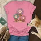 Pink t-shirt with a crystal ball dog paw graphic, paired with jeans, sneakers, and a small dog.