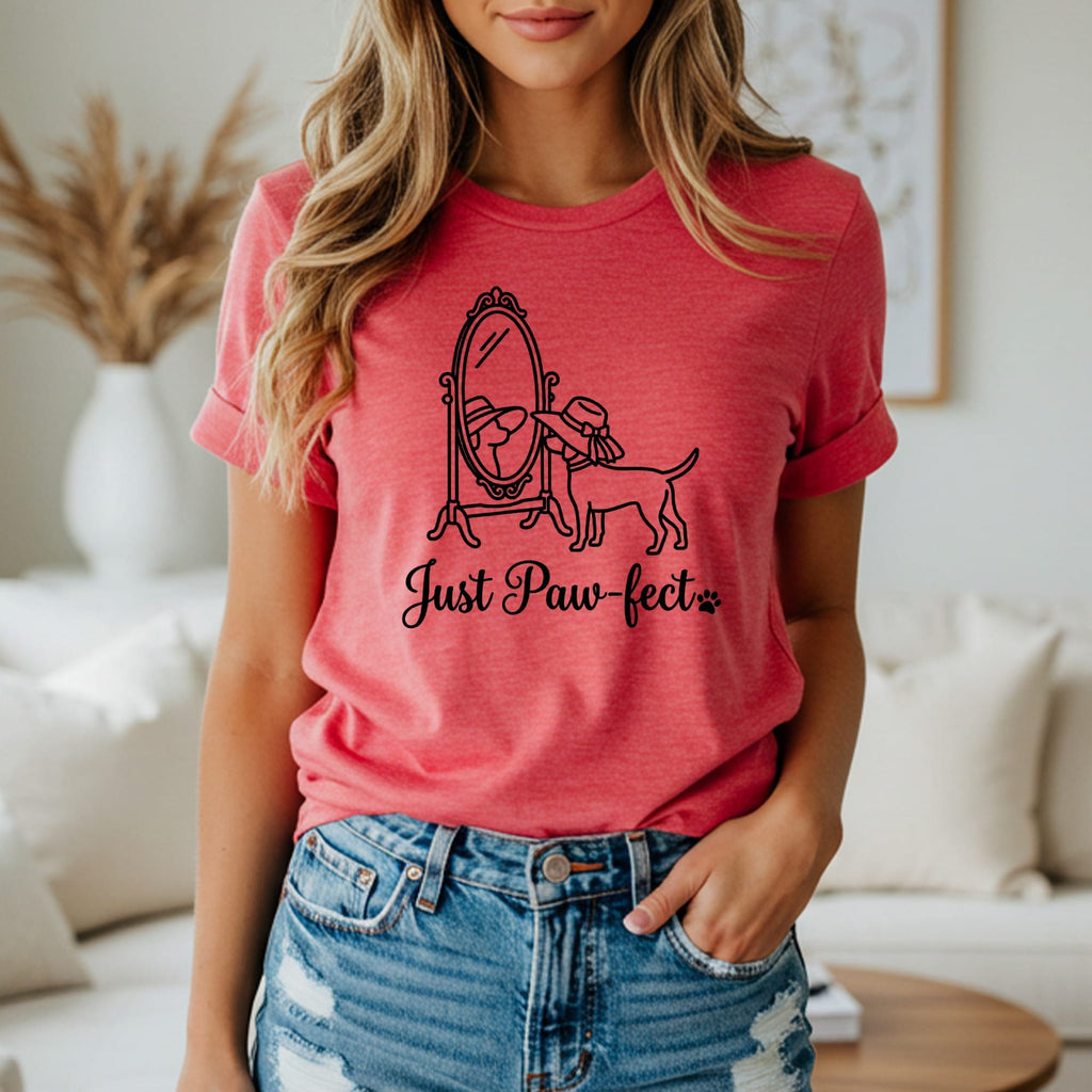 Dog looking in mirror with text "Just Paw-fect" on a pink shirt.
