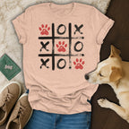 Peach t-shirt with a tic-tac-toe grid featuring paw prints and X's and O's.