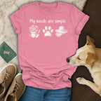 Pink t-shirt with "My needs are simple." text, flower pot, paw print, and hat.