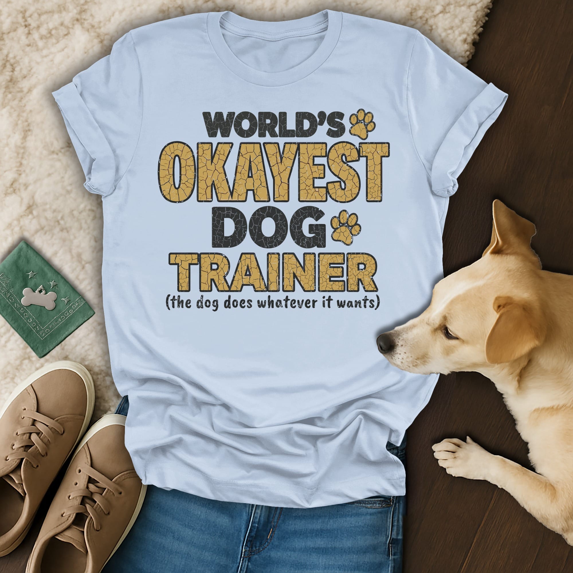 World's Okayest Dog Trainer shirt with dog paw prints and text.