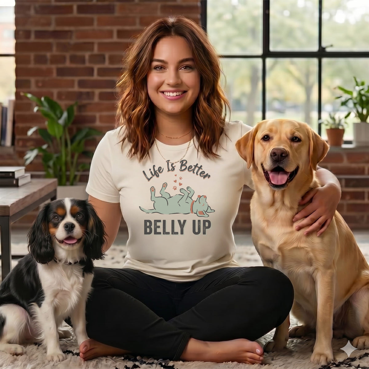 Woman with two dogs wearing a shirt that says "Life is Better Belly Up".