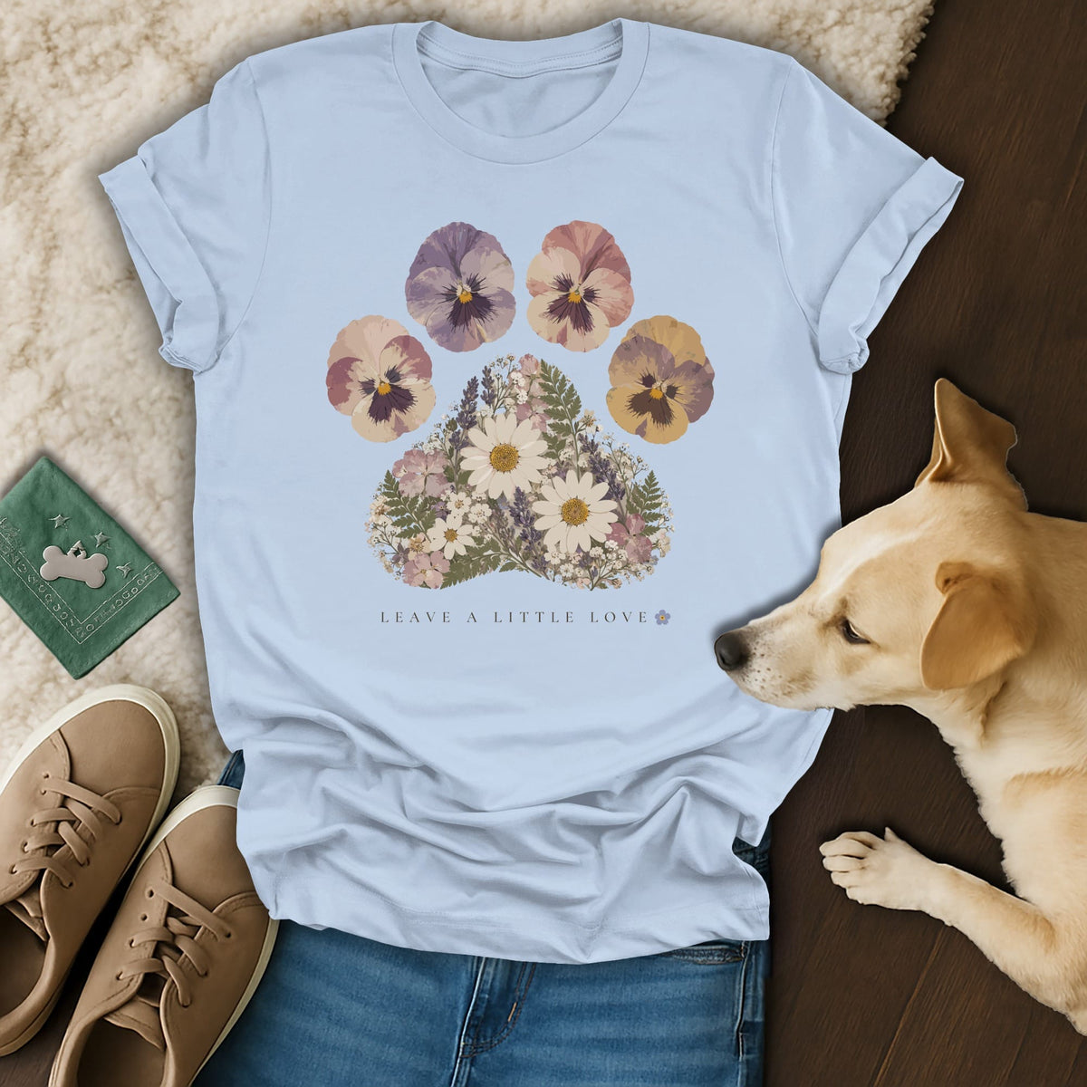 Light blue t-shirt featuring a floral paw print graphic with the text leave a little love.