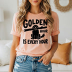 Peach t-shirt with "Golden Hour is Every Hour" and a dog with a stick.