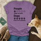 Purple t-shirt with black text and paw prints reading "People Judge my outfit. Dogs Loves me in pajamas."