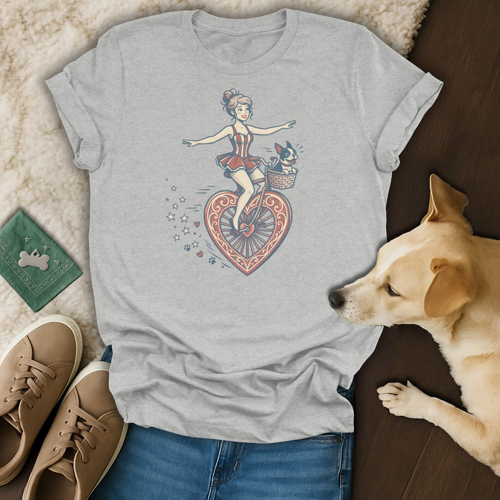 Grey t-shirt with a graphic of a woman on a heart-shaped bicycle and a dog in the basket.