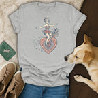 Grey t-shirt with a graphic of a woman on a heart-shaped bicycle and a dog in the basket.