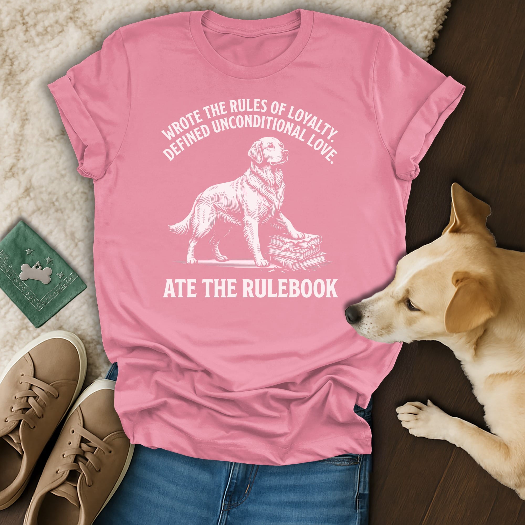 Pink t-shirt with white text and dog illustration: "Wrote the rules of loyalty, defined unconditional love. Ate the rulebook."