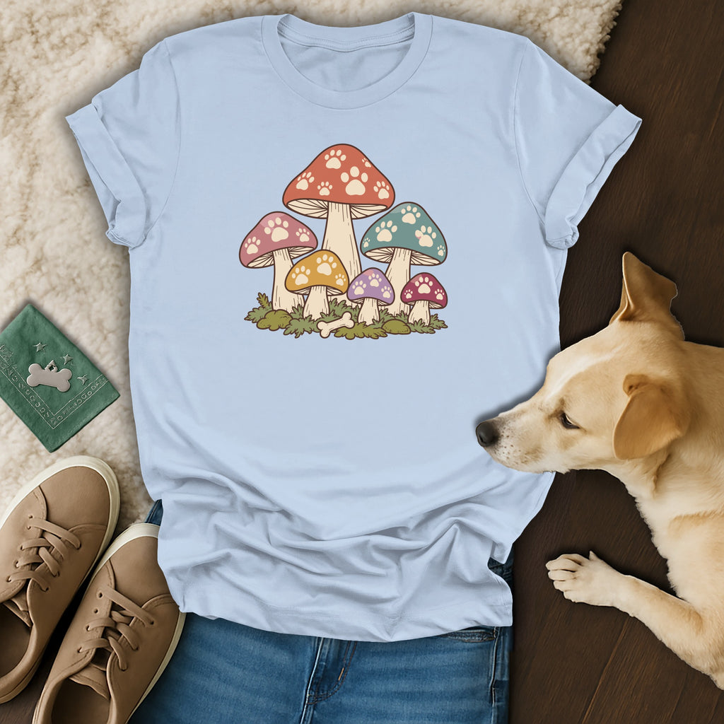 Light blue t-shirt featuring a colorful mushroom print with paw print details, alongside a sleeping dog, sneakers, and accessories.
