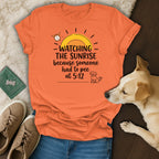 Orange t-shirt with "Watching the sunrise because someone had to pee at 5:12" text.