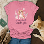 Pink t-shirt with a Cavalier King Charles Spaniel graphic, floral wreath, and text grows best beside you.