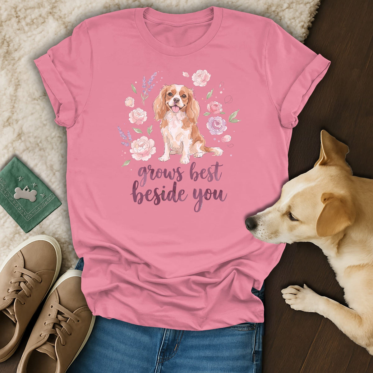 Pink t-shirt with a Cavalier King Charles Spaniel graphic, floral wreath, and text grows best beside you.