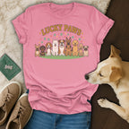 Pink t-shirt with cartoon dogs and "Lucky Paws" text, featuring a real dog nearby.