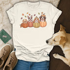 T-shirt with illustration of four dogs in pumpkins with autumn leaves.