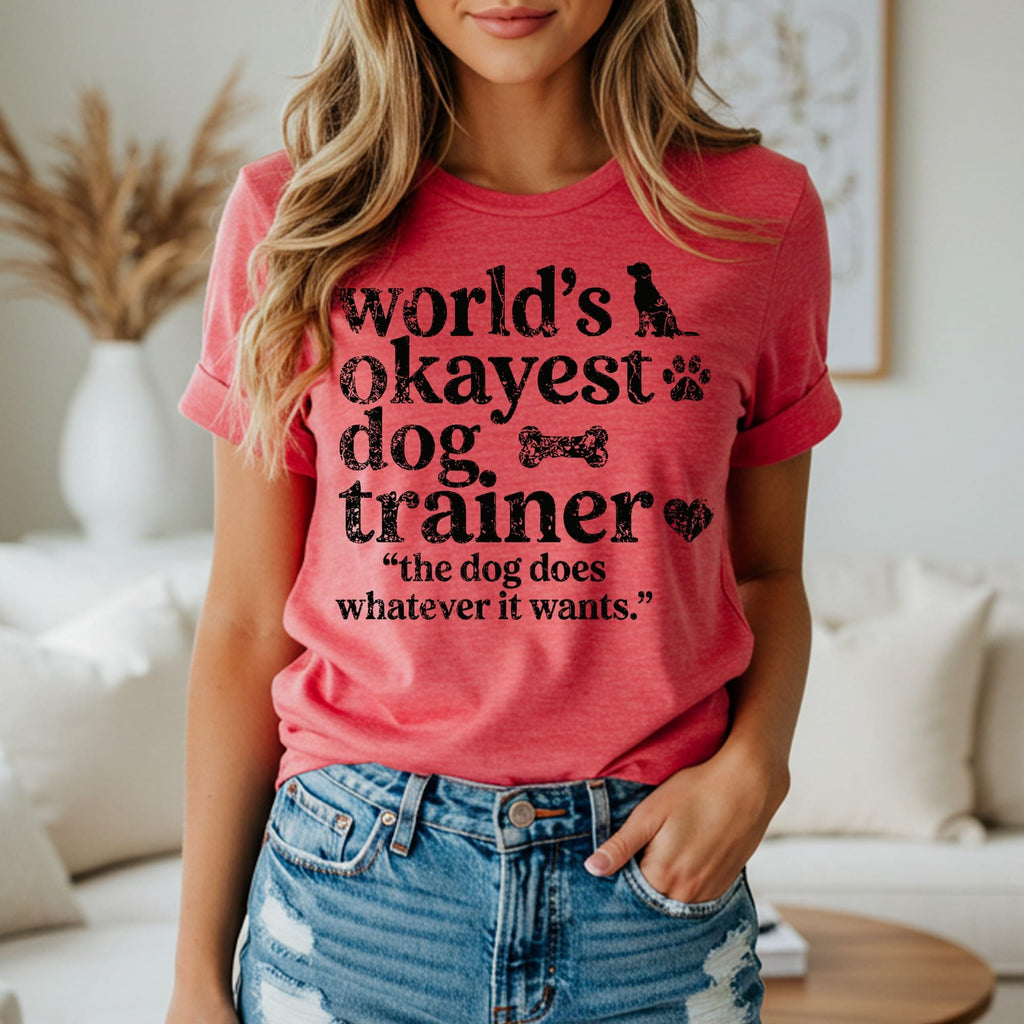 Red t-shirt with black text and dog-themed icons reading "World's Okayest Dog Trainer".