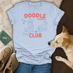 Light blue t-shirt with "Doodle Mom Club" text and line-art doodle dogs.