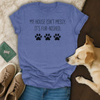 Blue t-shirt with "My house isn't messy. It's fur-nished." text and paw prints.