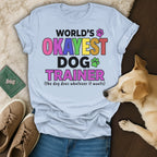 Light blue t-shirt with "World's Okayest Dog Trainer" text.