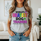Gray t-shirt with "World's Okayest Dog Trainer" text and paw prints.