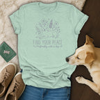 Light mint t-shirt with purple line art of a dog and flowers, and text.