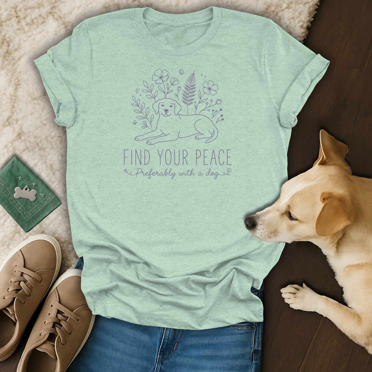 Light mint t-shirt with purple line art of a dog and flowers, and text.