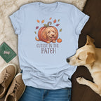 Light blue t-shirt with a dog in a pumpkin illustration and text "CUTEST IN THE PATCH".